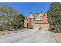 Charming brick home featuring a two-car garage, manicured landscaping, and a welcoming entrance at 3423 Mulberry Lane Ct, Dacula, GA 30019
