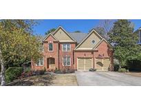 Charming two-story brick home featuring a well-manicured lawn and attached two-car garage at 3423 Mulberry Lane Ct, Dacula, GA 30019