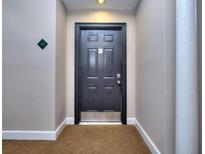 Neutral hallway featuring a solid dark-colored entry door and apartment number at 240 Renaissance Pkwy # 116, Atlanta, GA 30308