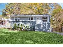 Charming single-story home boasts a well-maintained lawn and inviting front entrance with white stairs and gray accents at 2190 Lang Sw Dr, Atlanta, GA 30315