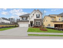 Charming two-story home with stone accents, a manicured lawn, and a two car garage at 4790 Briscoe Dr, Cumming, GA 30028
