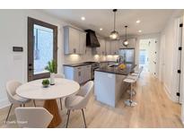 Bright, modern kitchen featuring stainless steel appliances, a large island, and a dining area with stylish chairs at 290 2Nd St, Fayetteville, GA 30214