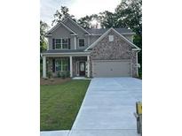 Charming two-story home with brick and siding, plus an attached two car garage and manicured lawn at 2260 Highridge Point Dr, Lithia Springs, GA 30122