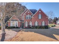 Brick two-story house with a large front yard and mature trees at 905 Fairview Club Cir, Dacula, GA 30019