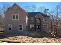 Brick two-story house with a three-car garage and a large front yard at 4251 Matisse Ln, Fairburn, GA 30213