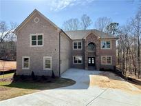 Stunning two-story brick home featuring a stone archway entrance and an attached garage on a spacious lot at 4251 Matisse Ln, Fairburn, GA 30213