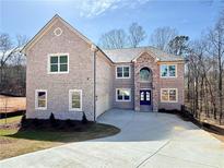 Charming two-story brick home featuring a manicured lawn and a spacious driveway, offering a welcoming curb appeal at 4251 Matisse Ln, Fairburn, GA 30213