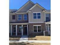 Charming two-story townhome featuring a brick facade, covered porch, and well-lit windows at 4849 Walkers Green, Mableton, GA 30126