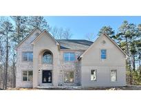 Beautiful two-story home featuring a stylish blend of gray brick and stucco, complemented by a dark gray roof at 990 Botanica Way, Fairburn, GA 30213