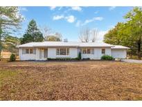 Newly renovated ranch home featuring a metal roof and updated landscaping at 13130 Providence Rd, Milton, GA 30009