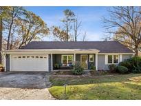 Gray house with white garage door and landscaping at 2956 Hogan Rd, East Point, GA 30344