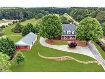 Aerial view of a two-story home, detached garage, and expansive lawn at 2054 Cook Rd, Oxford, GA 30054