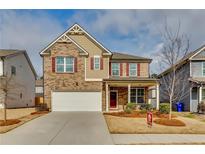 Charming two-story home with brick and siding, a well-manicured lawn, and a two-car garage at 7214 Gladstone Cir, Stonecrest, GA 30038