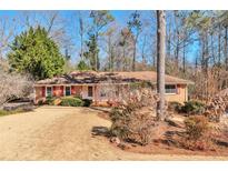 Brick ranch home with a manicured lawn at 1428 Ridgewood Sw Dr, Lilburn, GA 30047