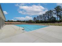 Community pool with a spacious deck and adjacent pool house at 606 Somerset Ct, Loganville, GA 30052