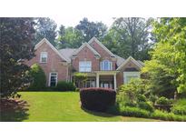 Charming brick home featuring a well-manicured lawn and mature trees at 2883 Thurleston Ln, Duluth, GA 30097
