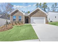 Charming brick home featuring a two-car garage, well-manicured lawn, and tasteful landscaping at 392 Village Ln, Fairburn, GA 30213