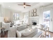 Bright living room featuring a fireplace, ceiling fan, and French doors leading to an outdoor space at 111 Swanton Hill Ct, Decatur, GA 30030