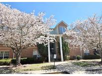 Brick condo building adorned with blossoming trees on a sunny day at 245 Amal Sw Dr # 1008, Atlanta, GA 30315