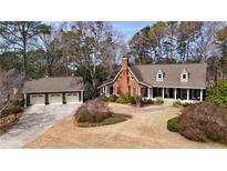 Beautiful brick two-story home featuring a three-car garage, dormer windows, and a welcoming front porch at 795 Rose Brooke Dr, Lawrenceville, GA 30045