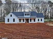 Newly constructed farmhouse with white siding, dark roof, and covered porch at 1632 Oleander Sw Dr, Lilburn, GA 30047