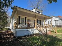 Charming home featuring a covered front porch with black shutters and landscaped yard at 31 N Broad N St, Porterdale, GA 30014