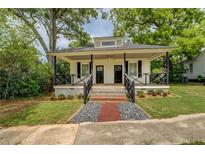 Charming home featuring a covered front porch with decorative railings and newly landscaped front yard at 31 N Broad N St, Porterdale, GA 30014