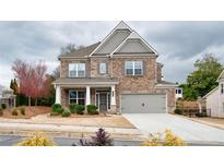 Beautiful two-story brick home featuring a covered porch and attached two-car garage at 5133 Greenard Watson Lane, Buford, GA 30518