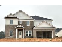 Two-story house with gray brick and beige siding, a three-car garage, and a covered entryway at 3121 Morris Hills Dr, Dacula, GA 30019