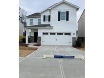Two-story white house with a two-car garage and landscaped yard at 7520 Saffron Ave, Covington, GA 30014