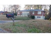 Brick ranch house with a deck and yard at 5910 Lakeshore Se Dr, Mableton, GA 30126