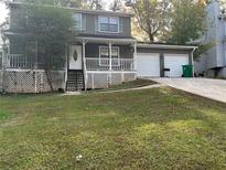 Charming two-story home featuring a front porch, a two-car garage, and a well-maintained front yard at 5585 Pennybrook Ct, Stone Mountain, GA 30087