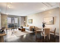 Bright living room features hardwood floors, modern furniture, neutral color scheme, and sliding glass doors to a balcony at 75 14Th St # 3640, Atlanta, GA 30309