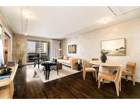 An open living room features dark hardwood floors, large windows, and sleek furniture at 75 14Th St # 3640, Atlanta, GA 30309