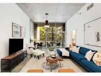 Bright living room with a blue sofa, modern decor and an open view to the outside terrace at 130 Arizona Ne Ave # 104, Atlanta, GA 30307