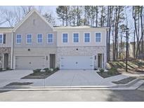 Charming townhome featuring a brick facade, a two-car garage, and well-maintained landscaping at 685 Sunstone Ln, Lawrenceville, GA 30043