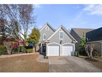 Charming home with a two-car garage, well-maintained lawn, and attractive architectural details at 1920 Rosebriar Dr, Marietta, GA 30066