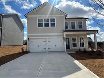 Charming two-story home with a two-car garage and a well-manicured lawn under a bright blue sky at 2116 Boxwood Se Cir, Conyers, GA 30094