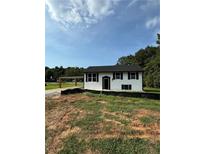Newly built home with black and white exterior, landscaped yard at 278 Valley Hill Se Rd, Riverdale, GA 30274