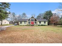Inviting single-Gathering home featuring a red front door and beautiful stonework accents at 275 Helen Ln, Stockbridge, GA 30281