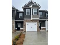 Townhome with gray siding, brick accents, black shutters and a single-car garage at 253 Ivey Ter # 48, Temple, GA 30179