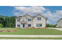 Charming two-story home with a brick facade, blue shutters, well-manicured lawn and professional landscaping at 173 Haverling Pass, Hampton, GA 30228