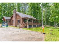 Charming log cabin home nestled on a spacious lot with mature trees at 58 Wesley Chapel Ln, Villa Rica, GA 30180