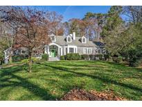 Gray shingled home with green door, large yard, and mature trees at 1225 W Wesley Nw Rd, Atlanta, GA 30327