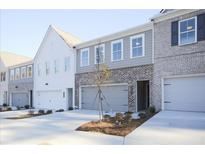 Charming townhome showcasing a brick and gray color scheme, complete with an attached one car garage at 905 Agate Ln, Lawrenceville, GA 30043