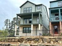 Two-story home featuring green siding, a covered porch, and a stone foundation at 1995 Catnap Ct, Chamblee, GA 30341