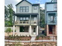 Charming two-story home with a welcoming front porch and black metal fence at 1995 Catnap Ct, Chamblee, GA 30341