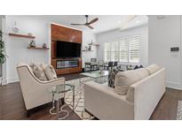 Bright living room featuring a sleek fireplace, a modern ceiling fan, and stylish decor at 165 Brush Creek Ct, Hampton, GA 30281