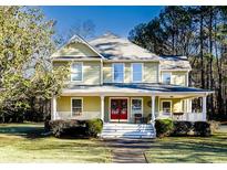 Two-story house with a wrap-around porch and landscaped yard at 180 Paula Dr, Tyrone, GA 30290
