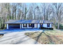 Ranch style home with attached two-car garage and landscaped yard at 1900 Mornington Ln, Snellville, GA 30078